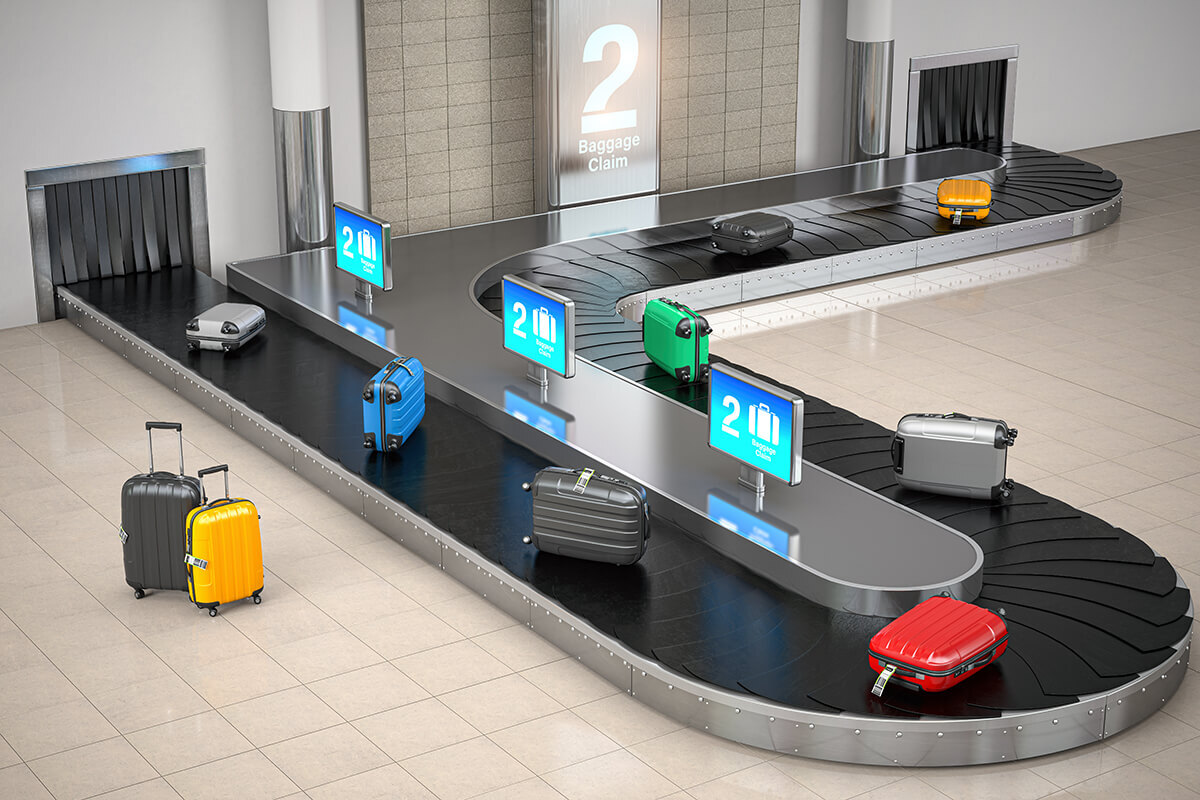 Airport baggage conveyor belt with luggage moving along the track.