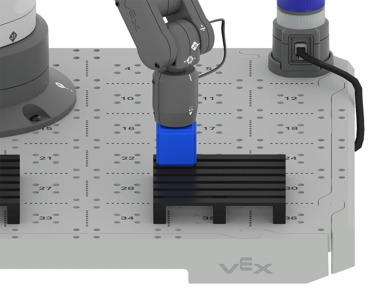 An angled view of the 6-Axis Arm with its Magnet Pickup tool placed on top of a blue cube that is on one corner of the pallet.