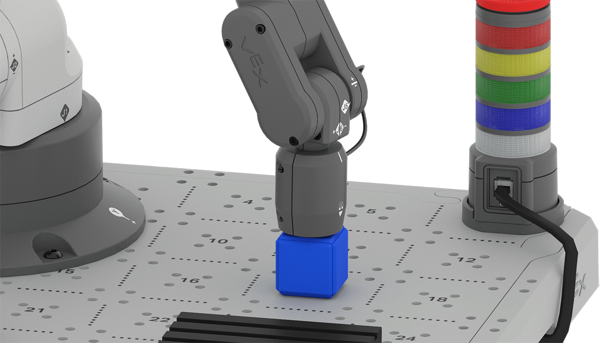 An angled view of the 6-Axis Arm equipped with the Magnet Pickup Tool. The tool is touching the top of a blue cube that is currently positioned on the tile's 17 position.