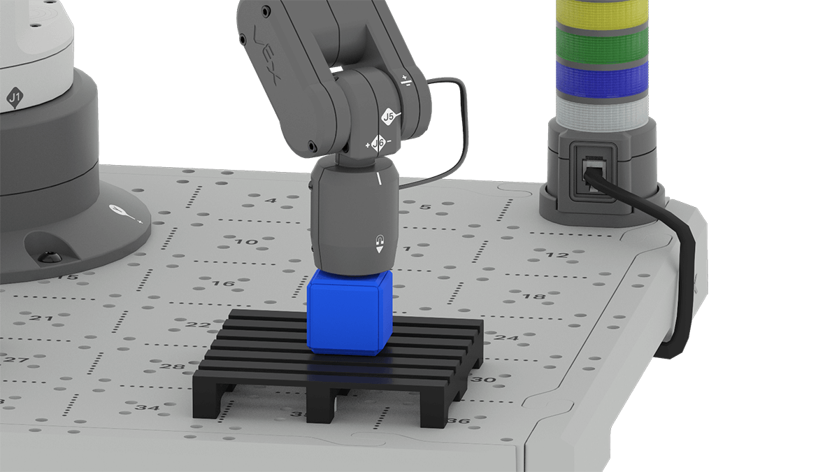 An angled view showing the 6-Axis Arm's Magnet Pickup tool placed on the top of a blue cube. The blue cube is placed on a pallet that is installed on the CTE Tile.