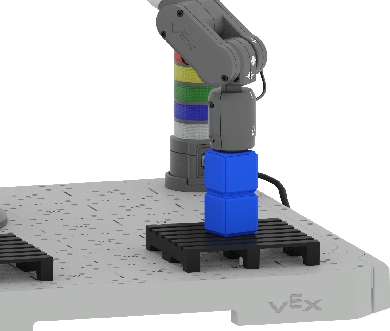 An angled view of the 6-Axis Arm with its Magnet Pickup Tool placed on top of two blue cubes. The two blue cubes are vertically stacked and placed in the center of a pallet that is installed on the CTE Tile.