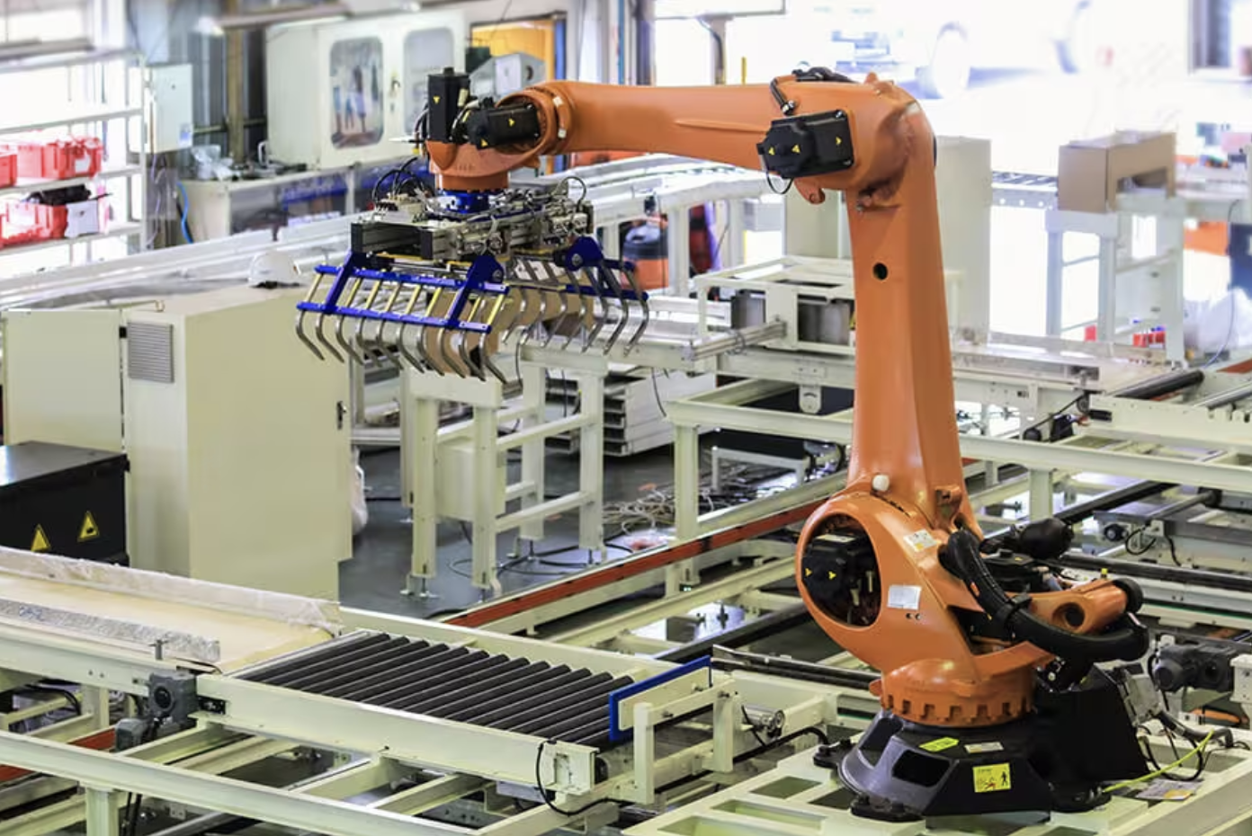 Industrial robot in a factory setting with a specialized robotic claw arm.