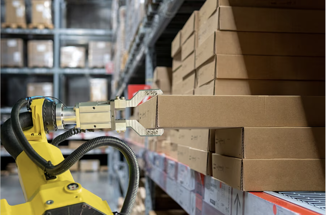 Robotic arm in a warehouse setting that can be used to move and organize boxes on shelves.