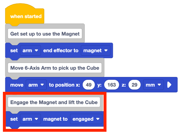 The same stack of blocks from before with two new blocks added to the bottom. These new blocks are a comment block that reads Engage the Magnet and Lift the Cube and a set arm magnet to engaged block. These two new blocks are highlighted with a red box.