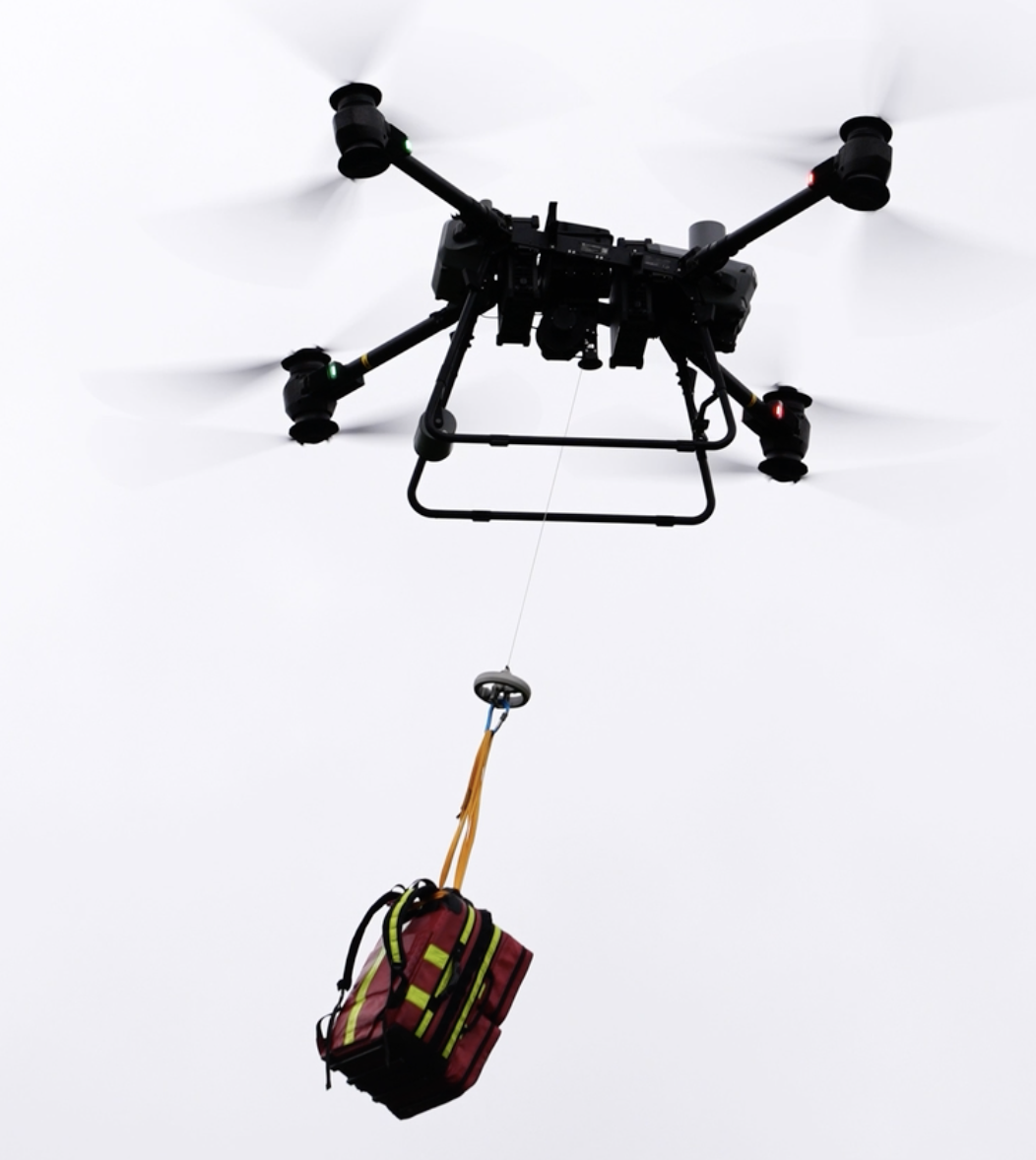 A drone lowers emergency supplies on a hook.