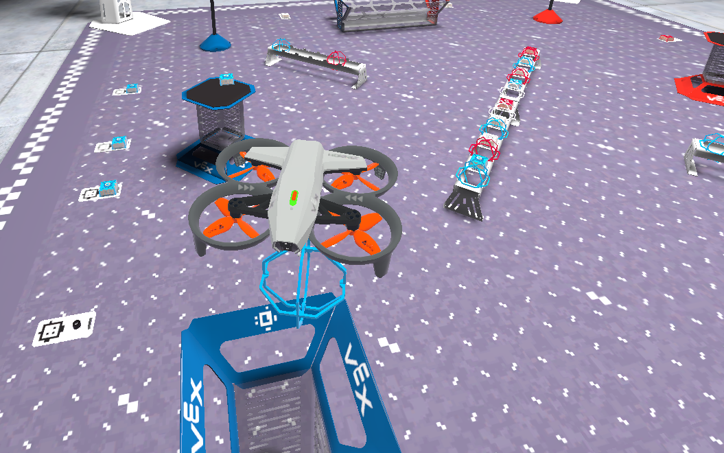 A screenshot from the VEX AIR Flight Simulator of the drone on the Competition layout carrying an orbit ball on the motorized hook, approaching the blue drop tower to score the ball.