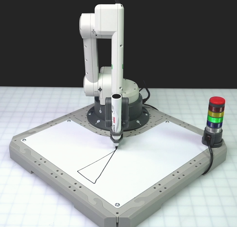 An angled view of the 6-Axis Robotic Arm showing the Arm equipped with the Pen Holder Tool drawing a line connecting the previously drawn line to the starting position to complete the triangle.