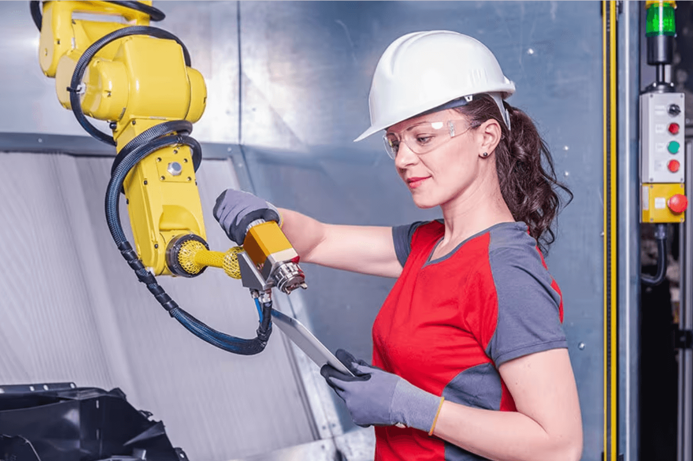 Gambar seorang pekerja sedang memeriksa keamanan lengan Robot Industri