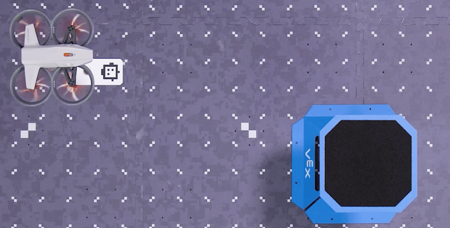Top down view of the drone as it picks up and moves a piece of cargo.